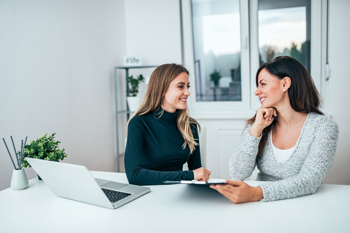 Two smiling female colleagues in the office. Working together.